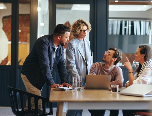 Business people having a meeting in a digital marketing agency. Group of business professionals discussing a project in an office. Teamwork and collaboration in a creative workplace.