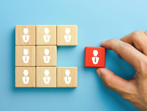 Building a good team, recruitment business and human resources concept, wooden blocks with people icon on table, blue background.